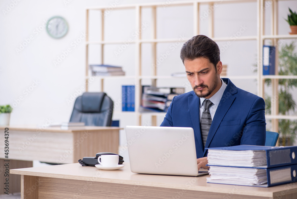 Young handsome employee working in the office