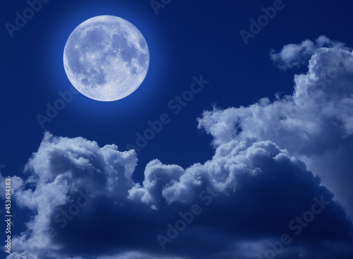 A full moon in a tragic night sky with clouds. A Halloween scene with a copy of the space.