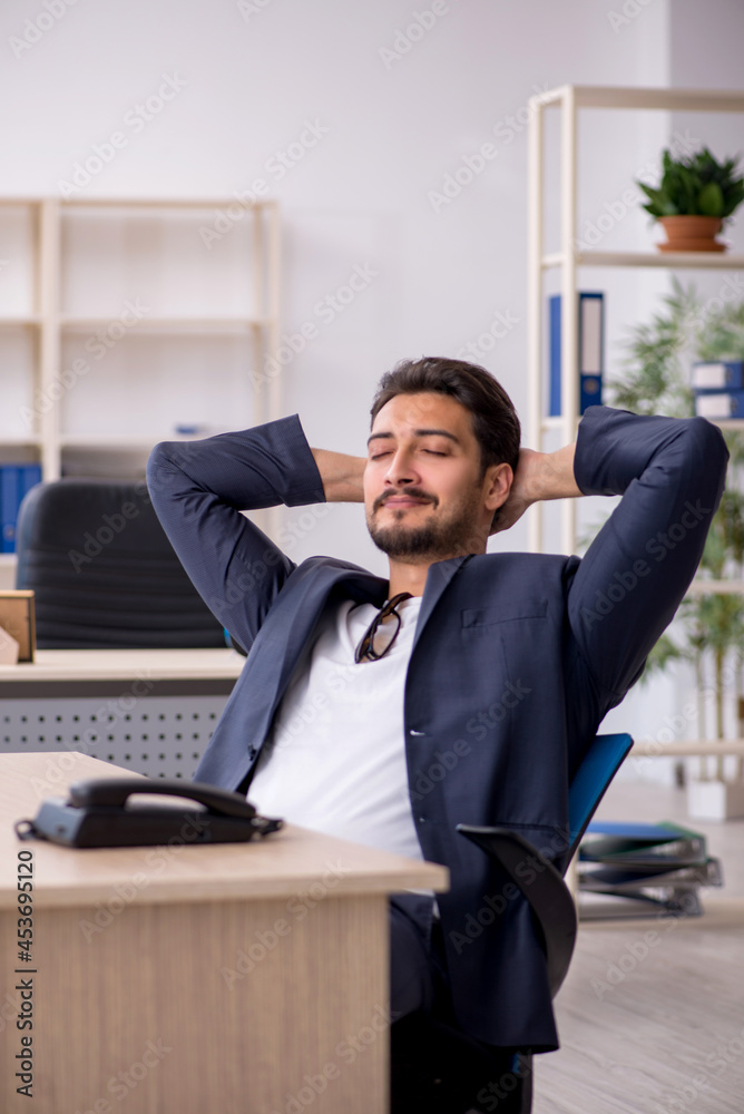 Fototapeta premium Young handsome employee working in the office