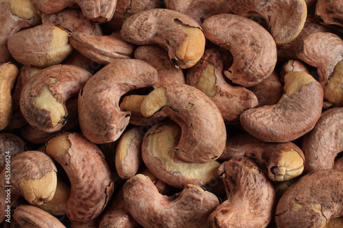 Heap of slightly roasted and salted cashews. Top-down view. Closeup. Food background