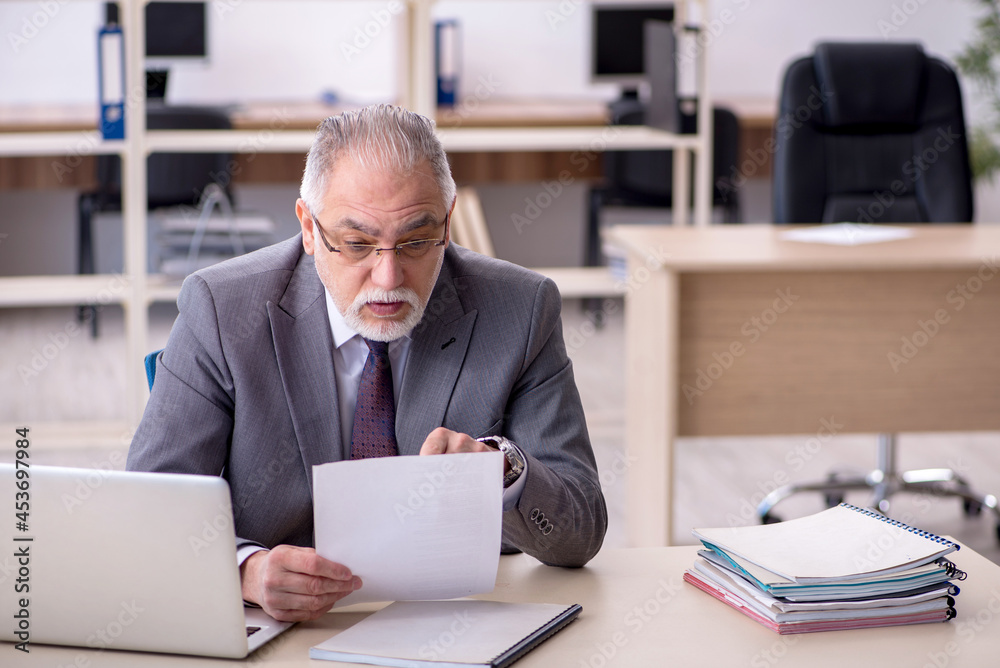 Old male employee and too much work in the office Old male employee and too much work in the office