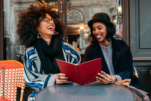 two Black women ihaving a great time at  a restaurant
