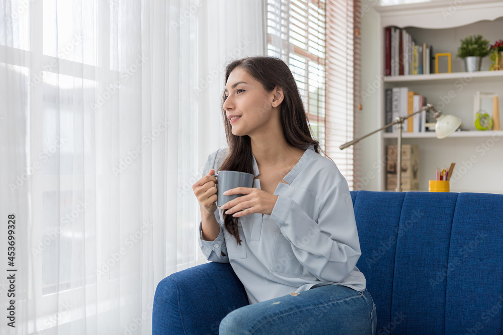 Young caucasian woman sitting sofa enjoying first morning coffee. Young caucasian woman sitting sofa enjoying first morning coffee.