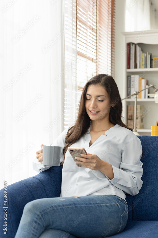Young caucasian woman sitting sofa enjoying first morning coffee. Young caucasian woman sitting sofa enjoying first morning coffee.