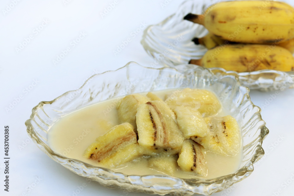 Homemade cultivated banana in coconut milk recipe on white background. One of popular traditional dessert of Thailand and Southeast Asia. Homemade cultivated banana in coconut milk recipe on white background. One of popular traditional dessert of Thailand and Southeast Asia.