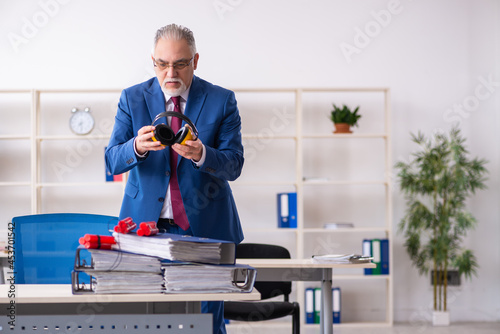 Old male employee with dynamite in the office photo