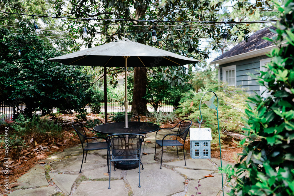 Backyard of a home with a patio table and unbrella and trees