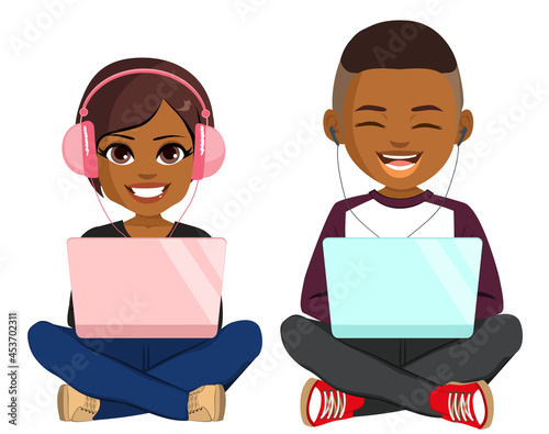 Two young black teenagers happy smiling sitting on floor with laptop wearing headphones 