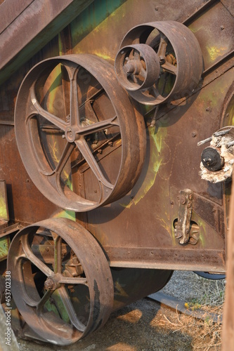 Mechanical details of a rusty, abandoned hay baler 