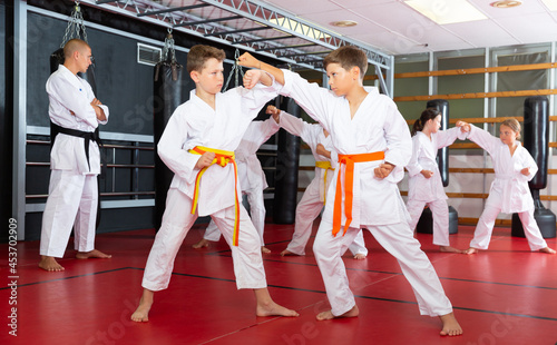 Young boys training in pair to use karate technique during class