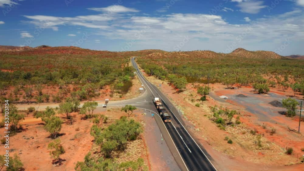 Road Train Driving Through Outback Landscape In Northern Territory Of Australia. aerial Road Train Driving Through Outback Landscape In Northern Territory Of Australia. aerial