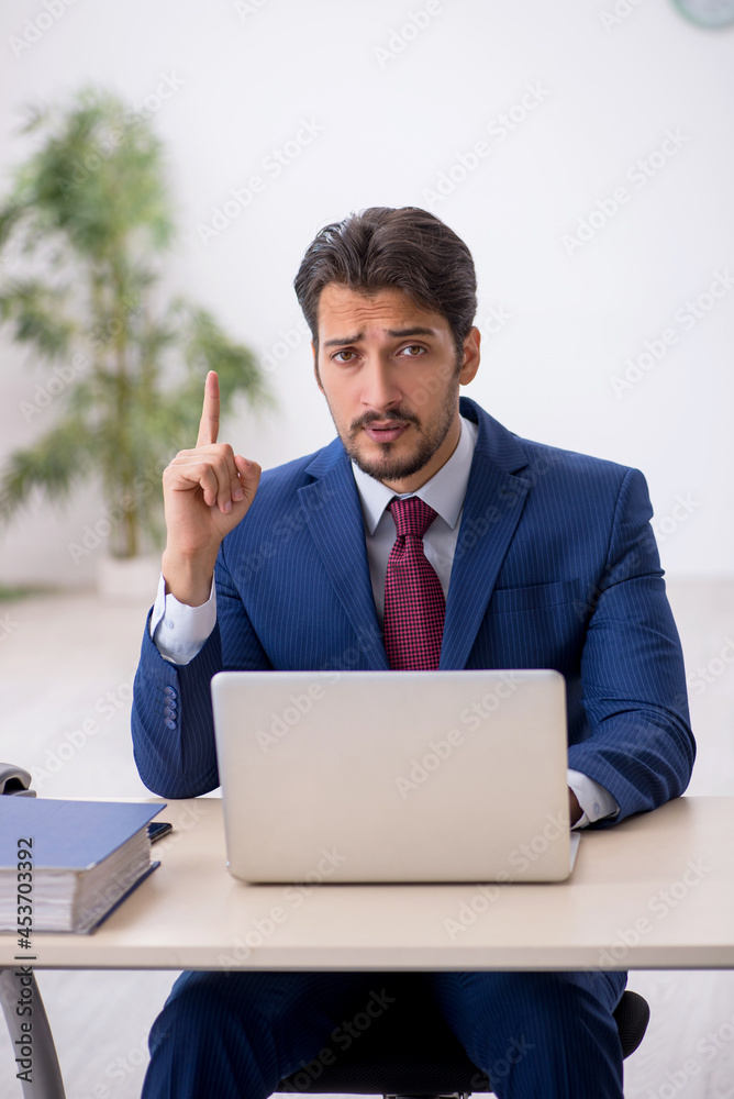 Young male employee working at workplace Young male employee working at workplace