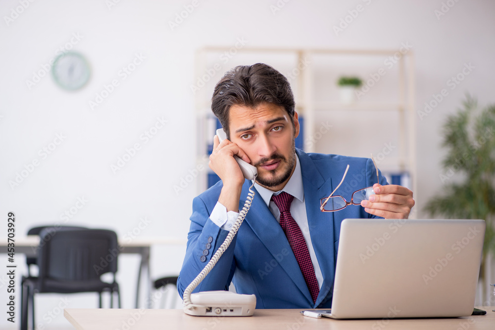 Young male employee sitting at workplace Young male employee sitting at workplace