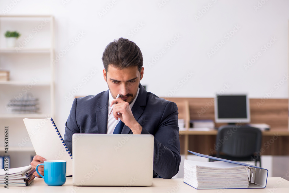 Young male employee sitting at workplace