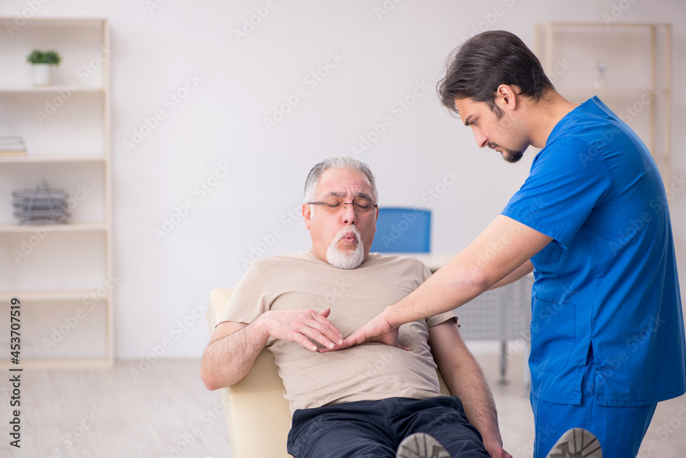 Old male patient visting young male doctor Old male patient visting young male doctor