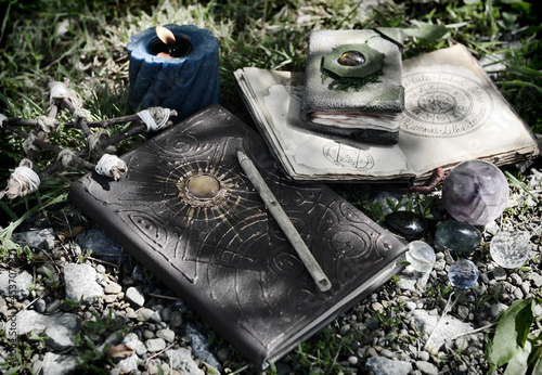 Still life with witch books of magic pells and candles in the garden. photo