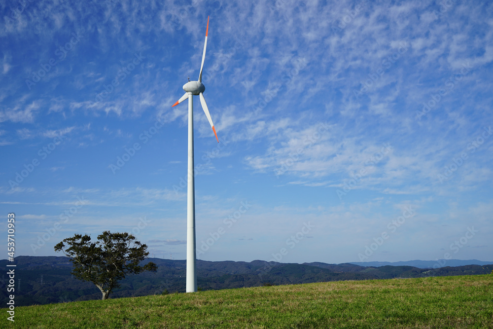 青空を背景に稲葉山の牧草地にある風力発電の風車1基