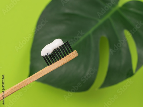 Wooden toothbrush on the background of a monstera leaf.