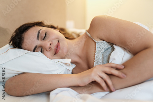 Obraz na plátně Latin girl sleeping in a very comfortable bed