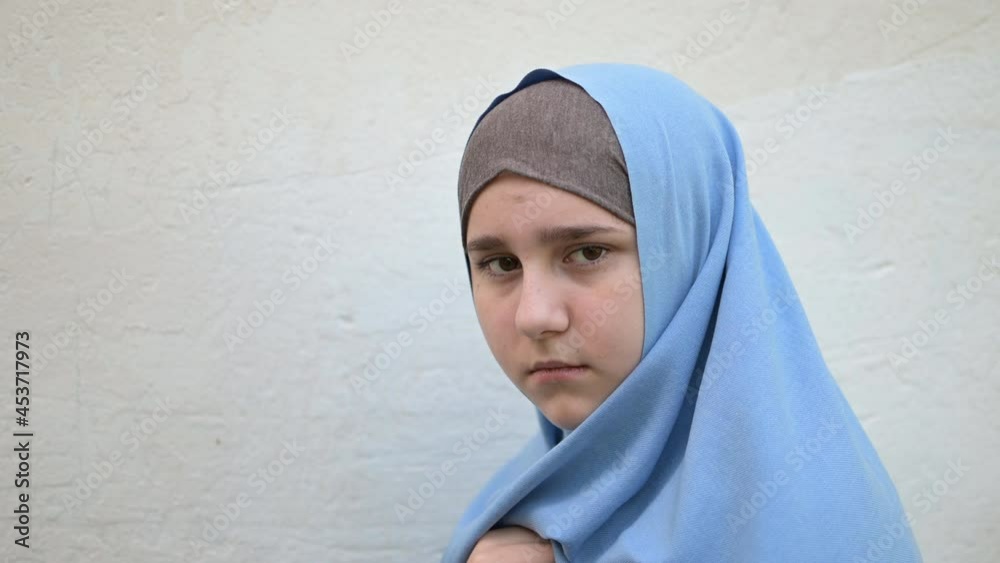 portrait of a homeless refugee teenage girl looks at the camera and turns away portrait of a homeless refugee teenage girl looks at the camera and turns away