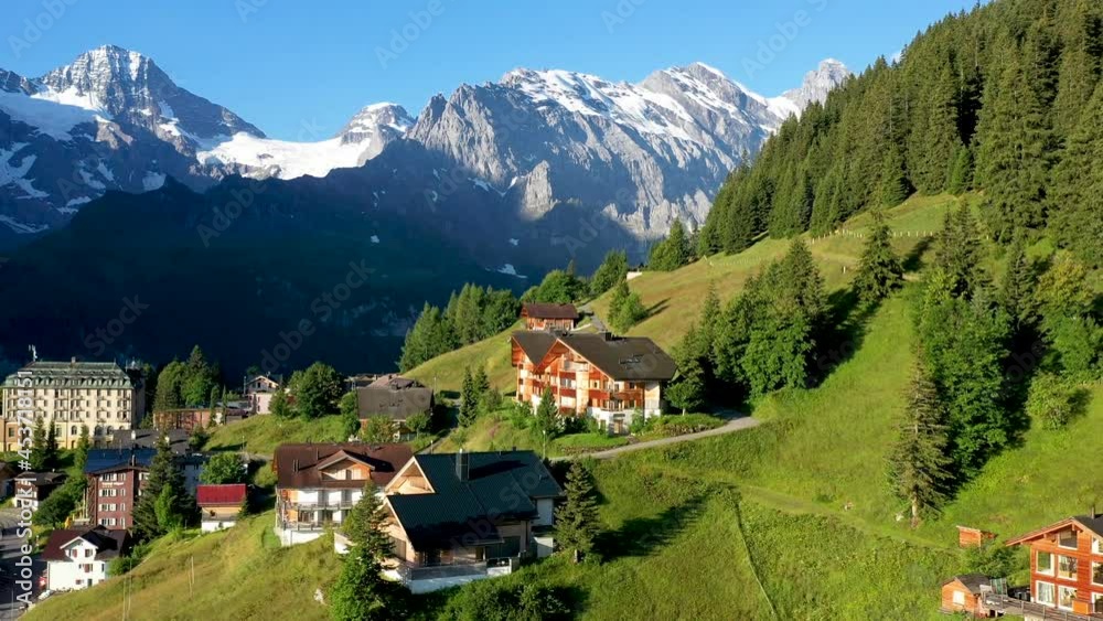 Drone shot of Murren, a traditional Walser mountain village in the Bernese Highlands of Switzerland. Flying over homes and hotels with mountains in the distance Drone shot of Murren, a traditional Walser mountain village in the Bernese Highlands of Switzerland. Flying over homes and hotels with mountains in the distance