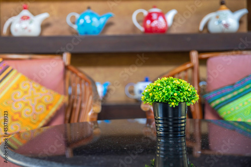 Bouquet of green flowers in a black vase on table in living room, © aumnat
