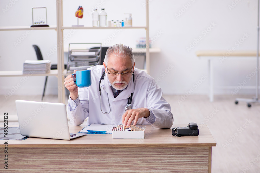 Old male doctor working in the clinic