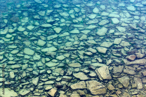 Background of transparent sea water and bottom with stones