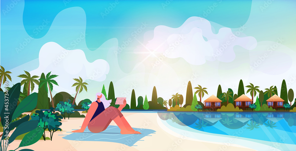 senior woman relaxing on tropical beach aged lady using tablet pc summer vacation active old age concept