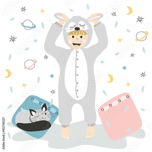 Child in kugurumi pajamas with a cat and pillows. Cute baby in pajamas on the background of pillows and feathers with stars. For the design of a children's album, poster or postcard.