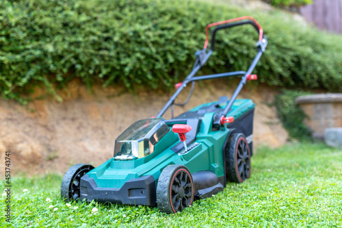 Fotografie Modern cordless battery electric lawn mowers in the garden