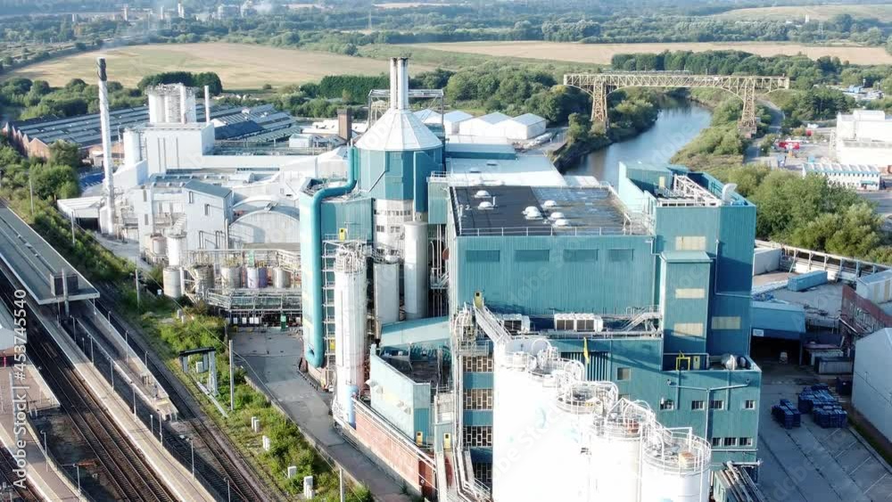 Industrial chemical manufacturing factory next to Warrington Bank Quay train tracks aerial view right orbit shot Industrial chemical manufacturing factory next to Warrington Bank Quay train tracks aerial view right orbit shot