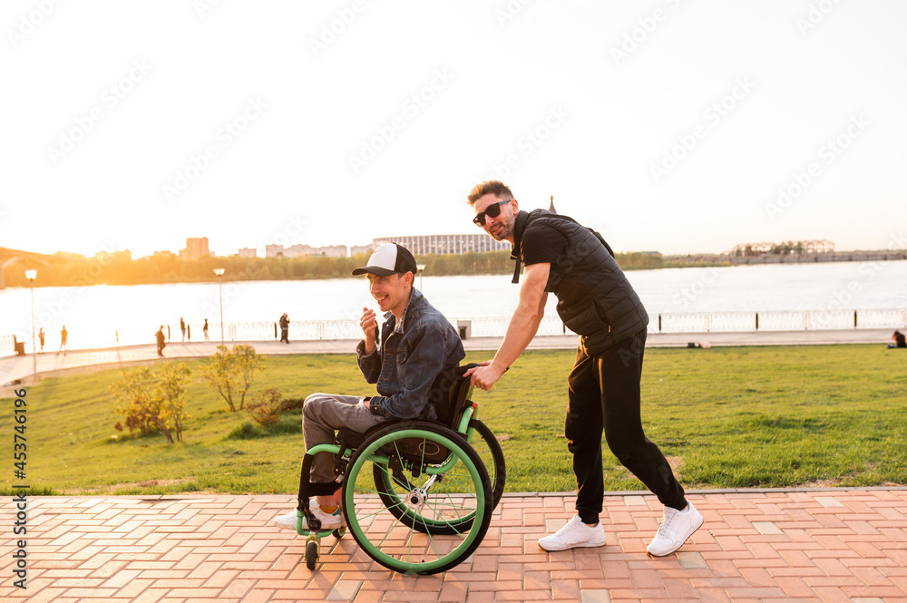 Young man in wheelchair and his friend walk outdoors