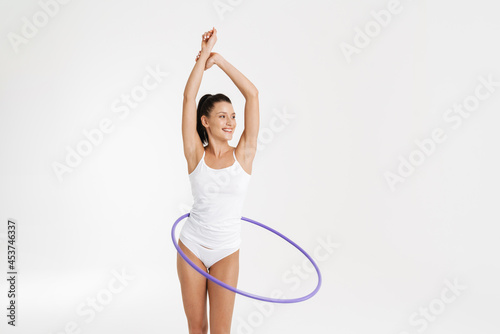 European woman wearing underwear doing exercise with hula-hoop