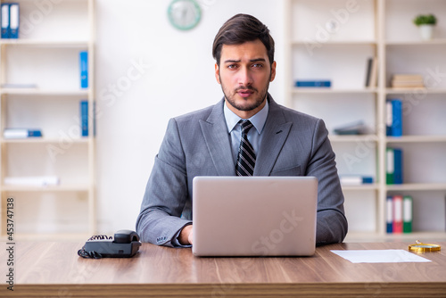 Young handsome businessman employee working in the office