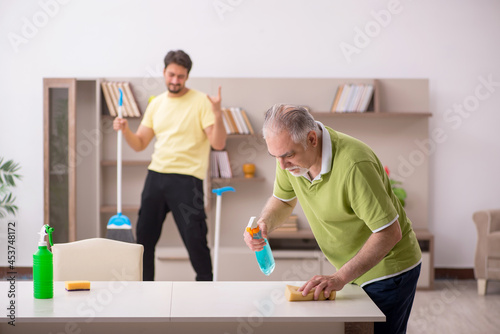 Two male contractors cleaning the house © Elnur