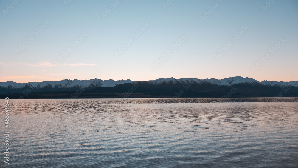 sunset over the lake snowcapped mountains in the background