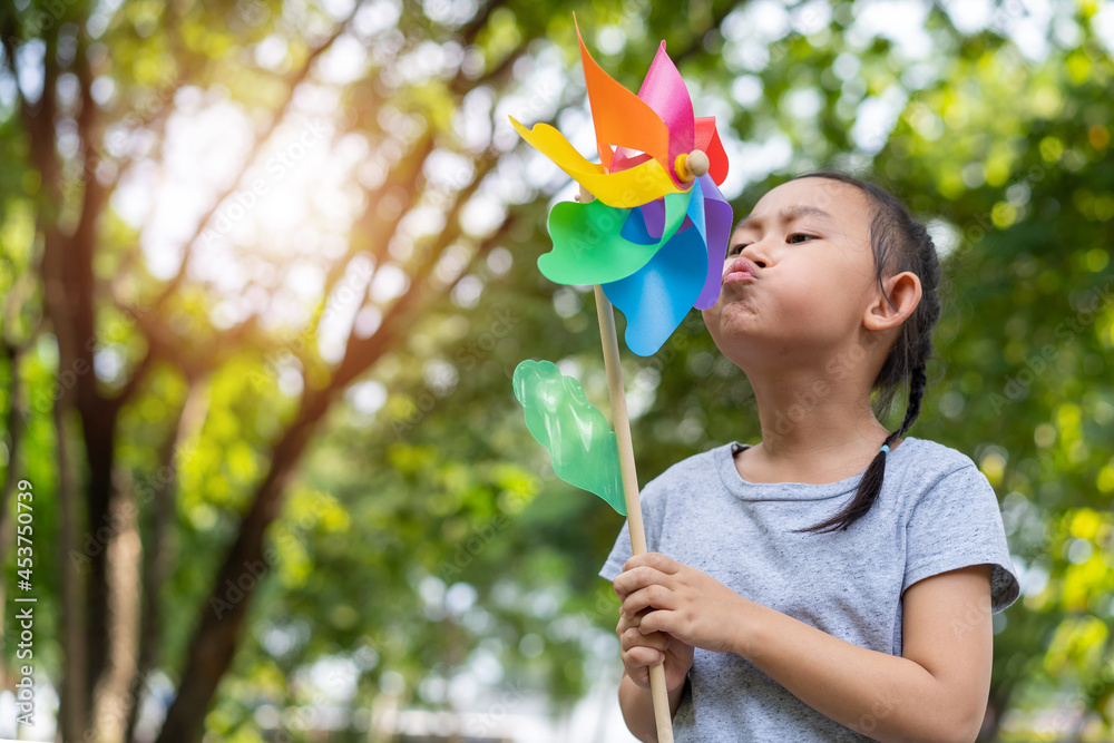 © kromkrathog - Asian little girl playing with paper windmill © kromkrathog - Asian little girl playing with paper windmill