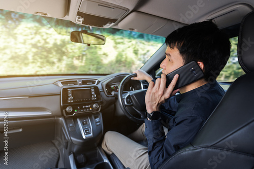 man driving a car and talking on mobile phone