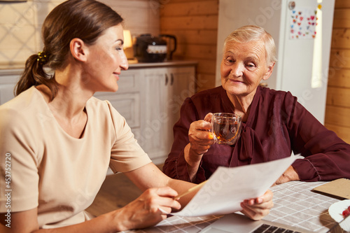 Person holding contract while senior woman giving her opinion about it