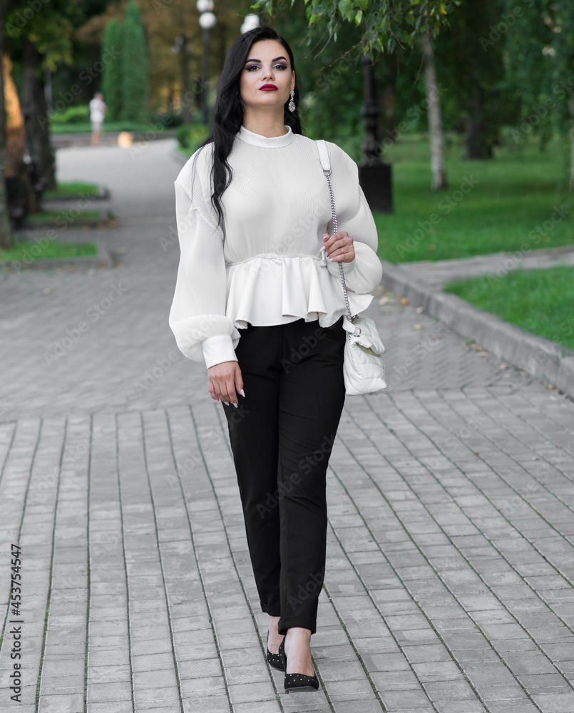 Portrait of a beautiful, young and attractive Caucasian brunette girl. Elegant girl posing in the summer in the park. Fashion concept. Portrait of a beautiful, young and attractive Caucasian brunette girl. Elegant girl posing in the summer in the park. Fashion concept.