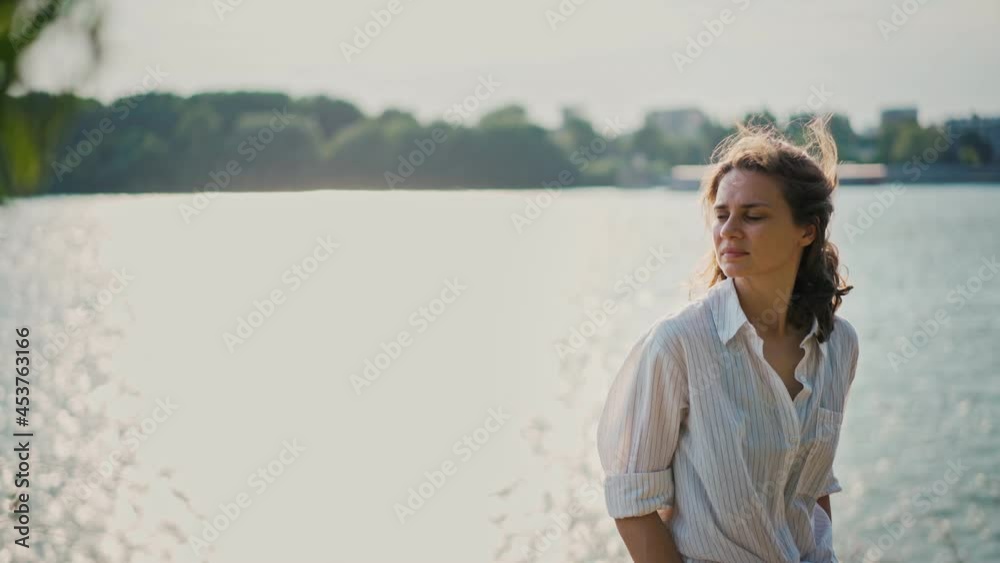 Portrait of a beautiful young woman enjoying a top view and the fresh air. The wind blows the girl curly hair.