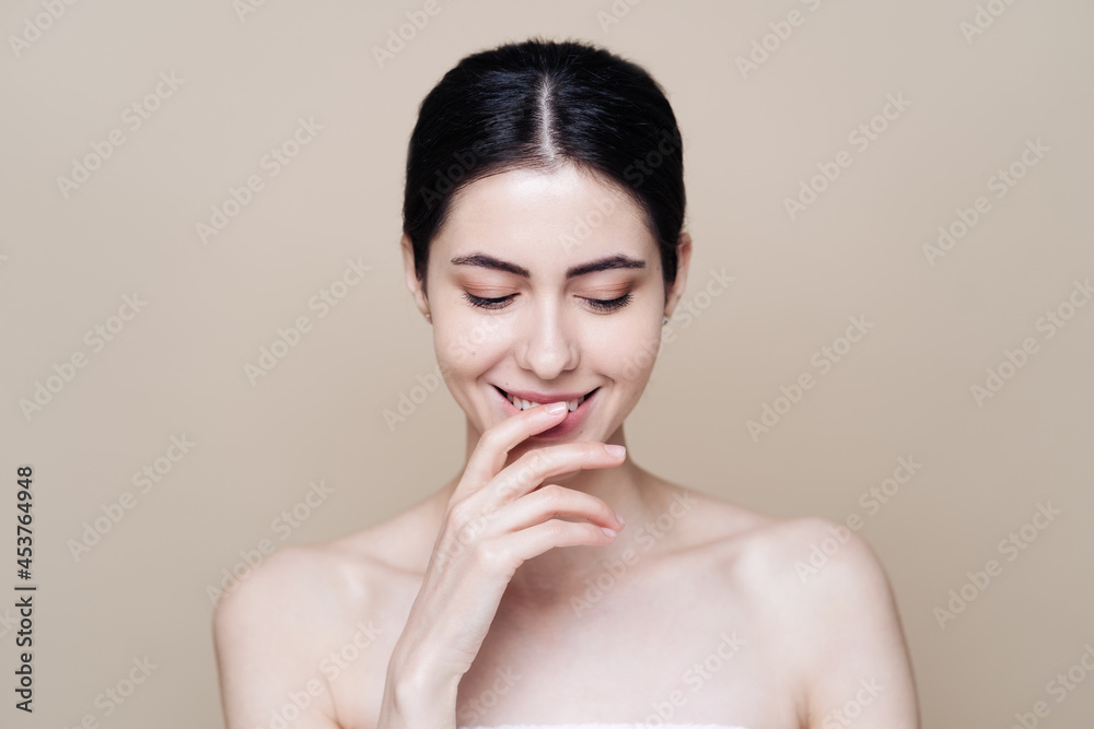 Beautiful young Caucasian woman with clean fresh skin on beige background, Face care, Facial treatment, Cosmetology, beauty and spa, brunette women portrait