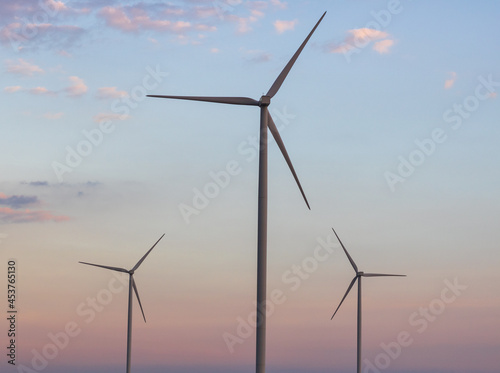 Windmills for electric power production at sunset.