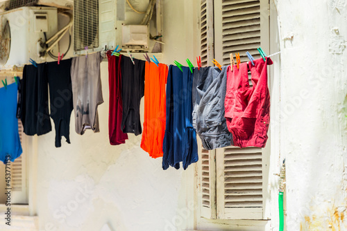 Clean, washed clothes are dried on a rope with clothespins in the outdoors © kosmos111