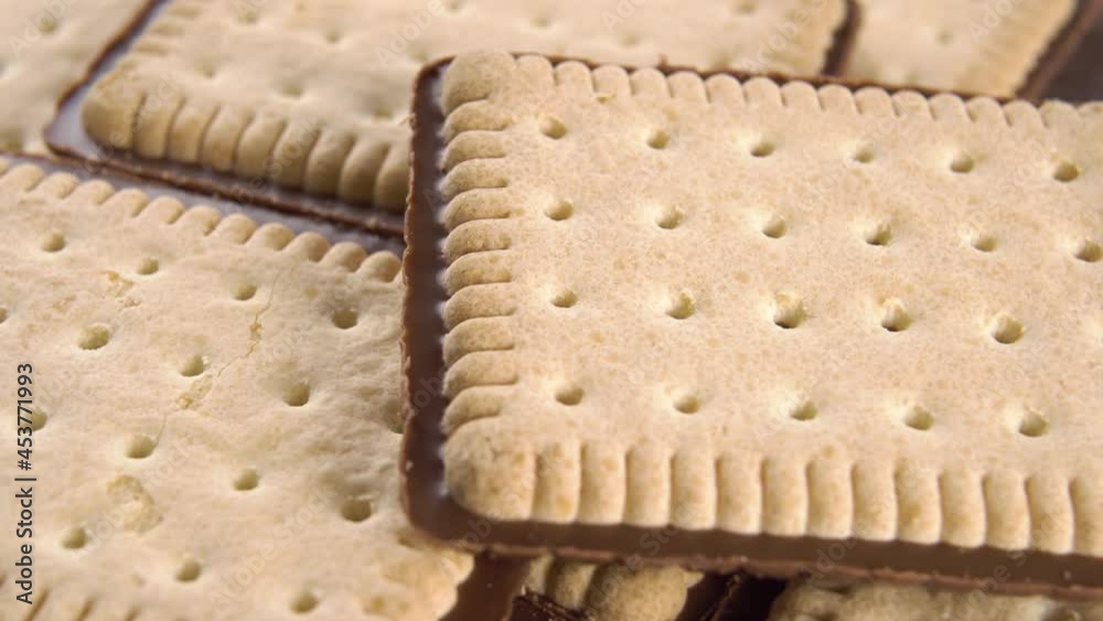Crispy biscuits with a chocolate layer close up rotates. Macro. Patterned surface. Selective focus
