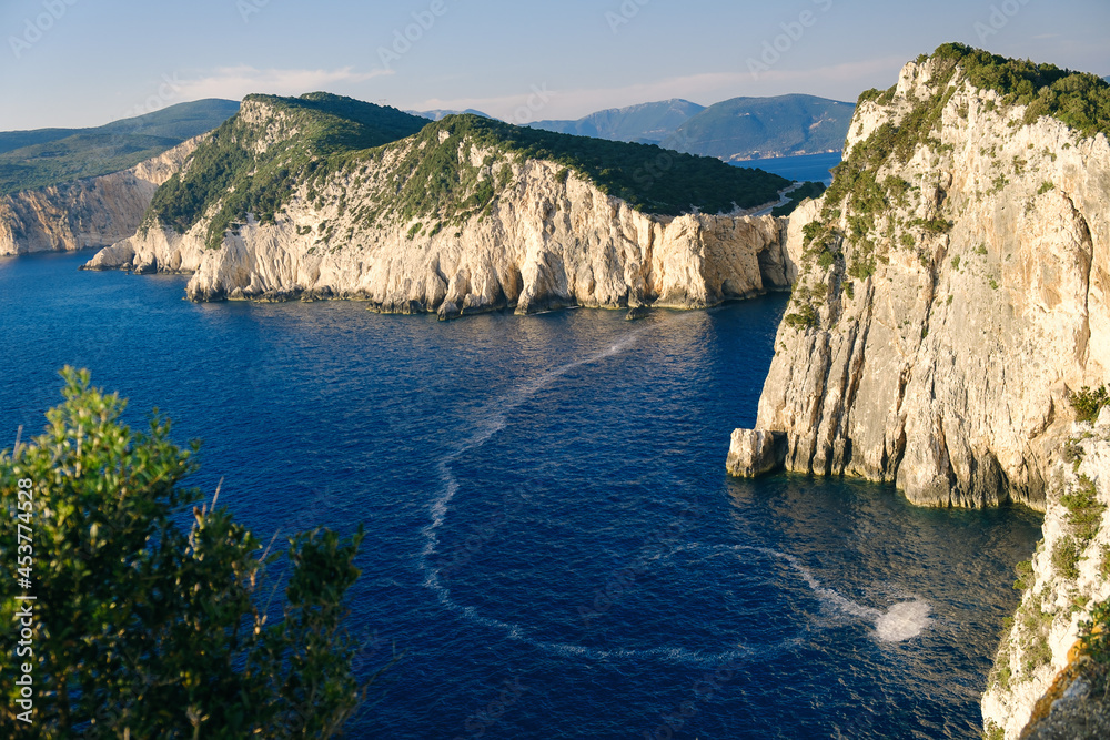 Scenic seascape with stone cliffs of island on background.