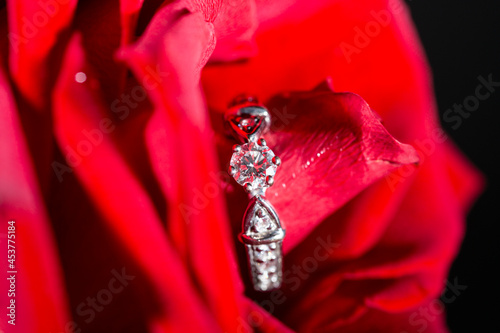 white gold ring with diamonds in red rose petals