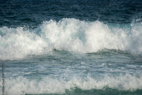 turquoise waves crashing at the beach © Em Neems Photography