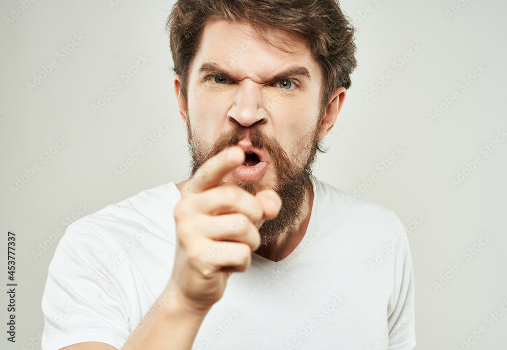 emotional man in a white t-shirt irritated facial expression close-up emotional man in a white t-shirt irritated facial expression close-up